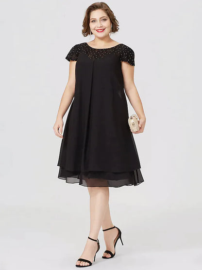 Plus size woman wearing a black chiffon lace Mother of the Bride dress, front view.