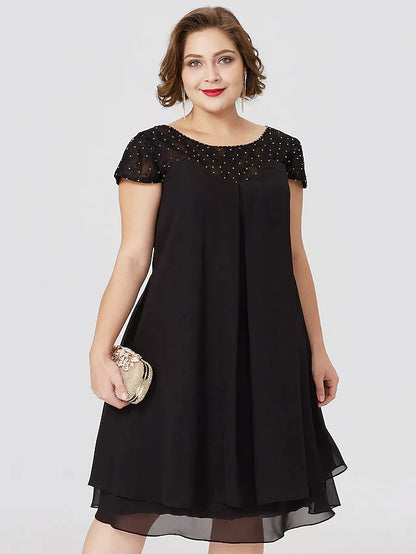 Side profile of the elegant black plus size dress, showing pleats and knee length.