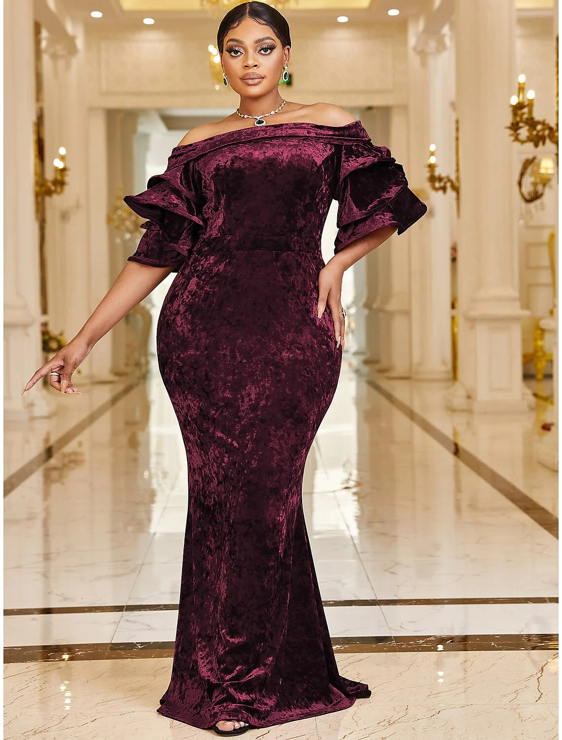 Plus size velvet mermaid gown with off-shoulder neckline and ruffles.