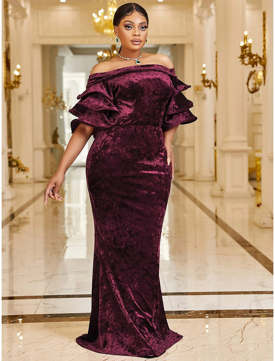 Woman posing in a luxurious plus size velvet mermaid cocktail dress.