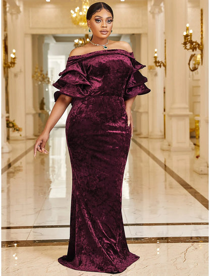 Woman posing in a luxurious plus size velvet mermaid cocktail dress.