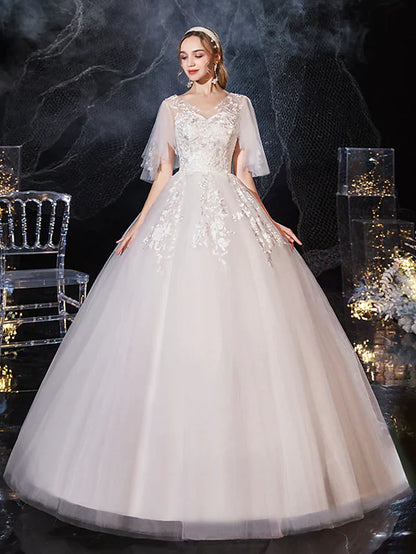 Bride wearing a V-neck half-sleeve lace tulle princess ball gown wedding dress with appliques.