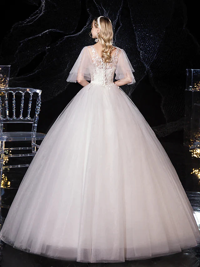 Close-up of the V-neckline and lace appliques on a bridal gown.