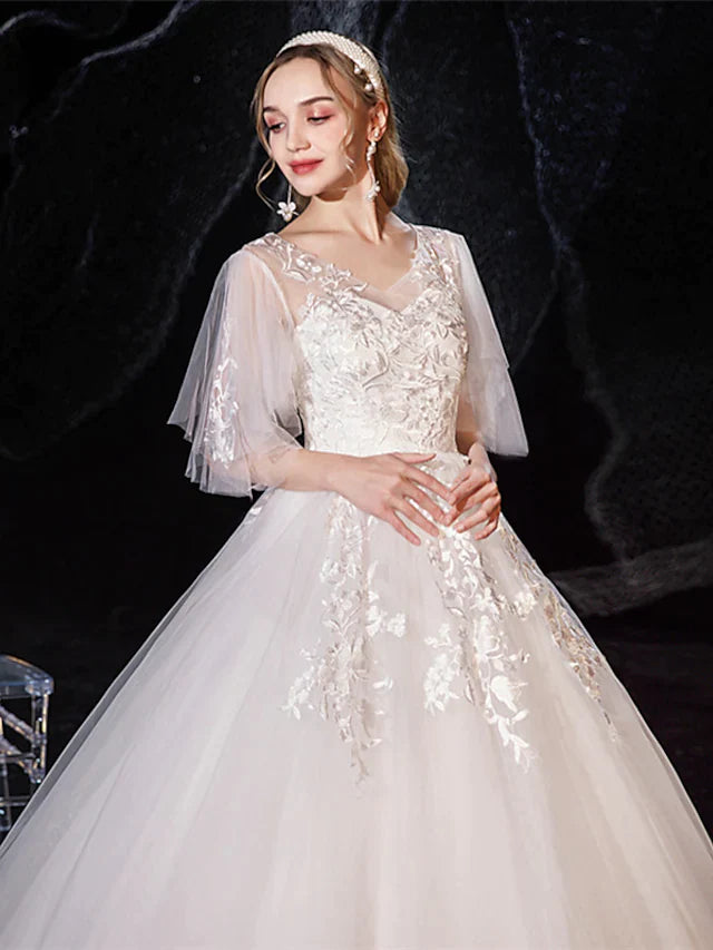 Back view of a bride in a floor-length princess wedding dress with intricate lace details.