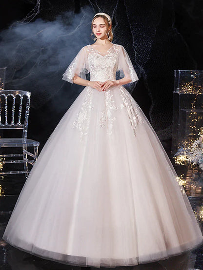 Side profile of a bride in a romantic half-sleeve ball gown wedding dress.
