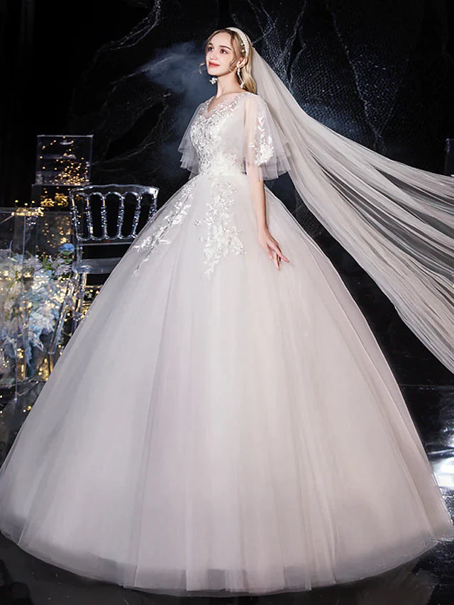 Detailed view of the lace and tulle fabric with appliques on a wedding dress.