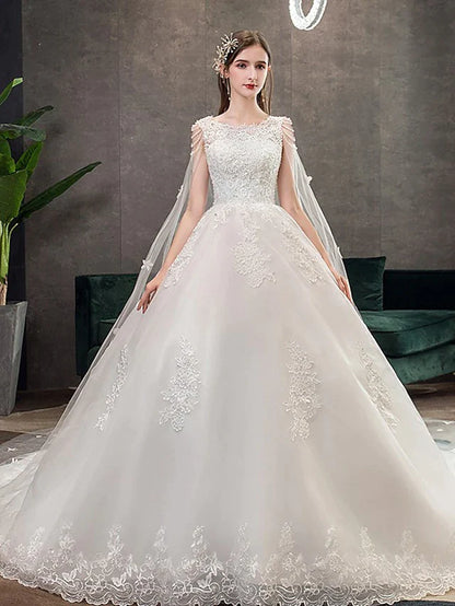 Model wearing an elegant Princess Ball Gown Wedding Dress with jewel neck, lace appliques, and chapel train.