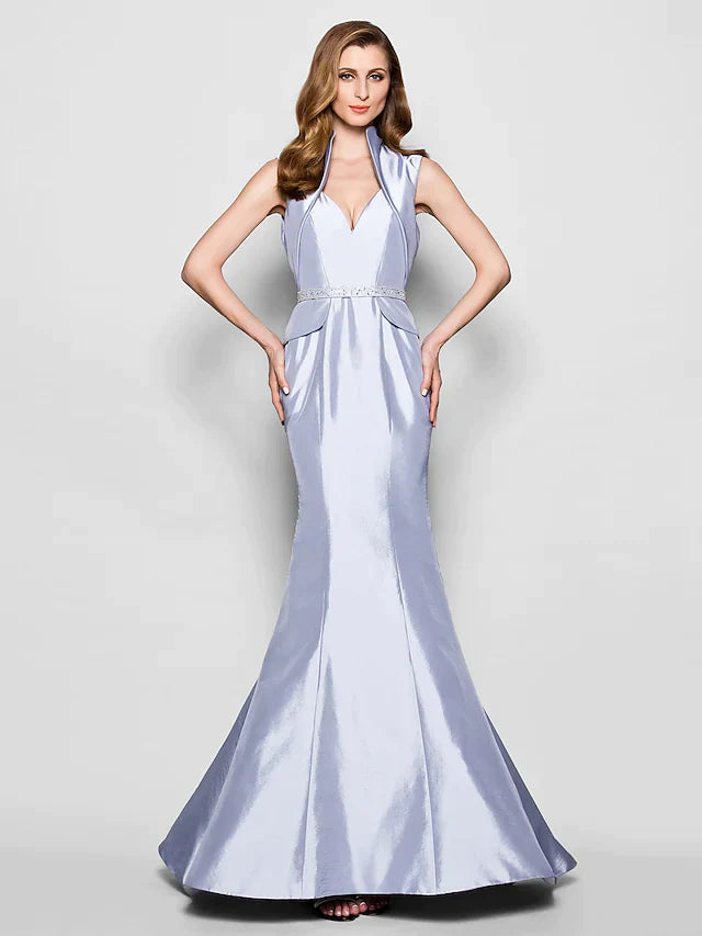 Woman wearing an elegant Queen Anne taffeta Mother of the Bride dress with a sash and beading.