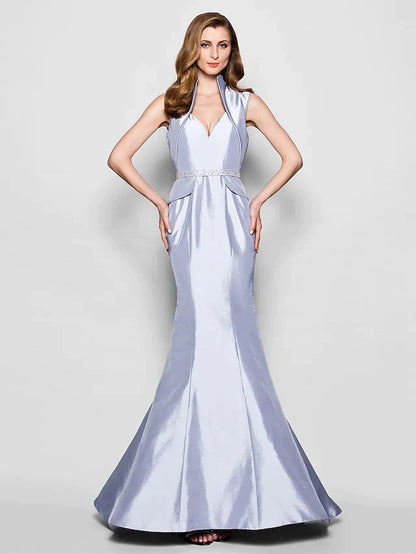 Woman wearing an elegant Queen Anne taffeta Mother of the Bride dress with a sash and beading.