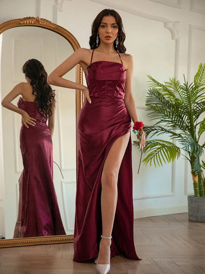 Model wearing an elegant ruched halter elastic woven satin floor-length prom dress.