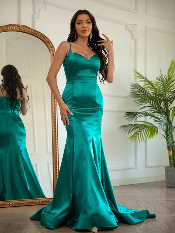 Woman wearing an elegant light-colored ruched V-neck satin prom dress.