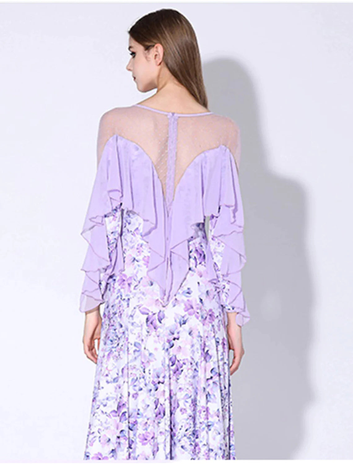 Back view of a woman dancing in a ruffled long sleeve performance dress.