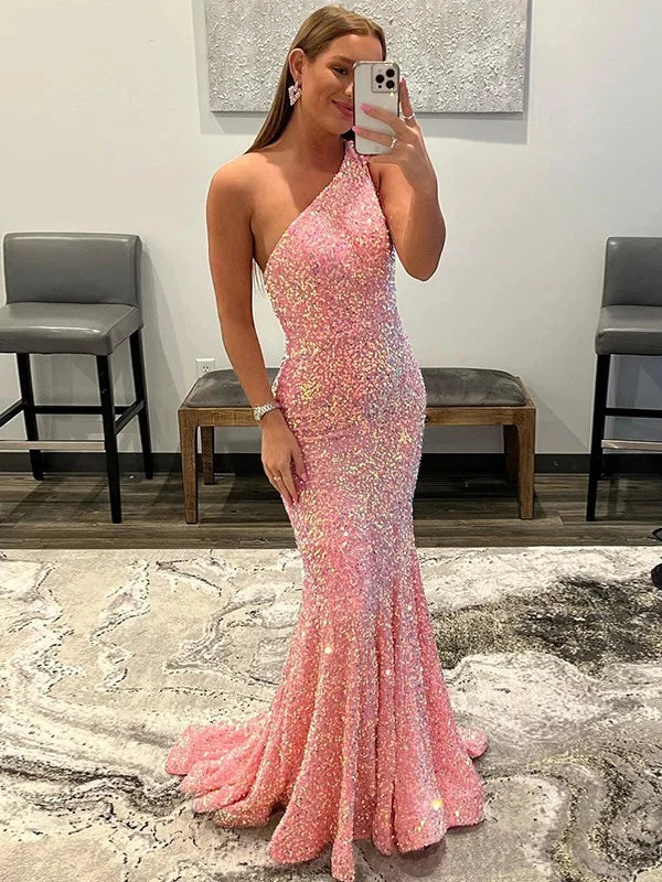 Woman wearing an elegant dark blue one-shoulder sequin prom dress with ruffles.