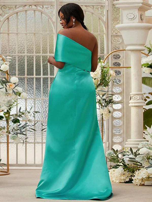 Side view of a woman in a green satin ruched one-shoulder long bridesmaid dress, showcasing the flowing skirt.