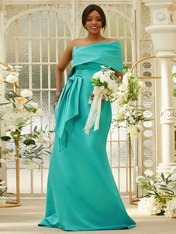 Back view of a woman wearing a green satin ruched one-shoulder long bridesmaid dress, highlighting the elegant drape.