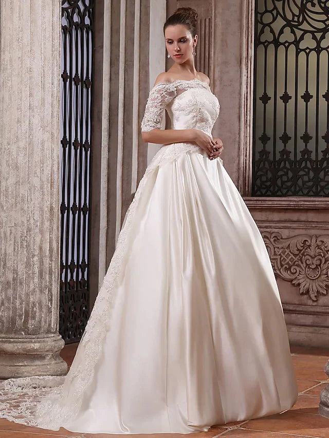 Close-up of the scalloped off-shoulder neckline and half sleeves of the wedding dress.