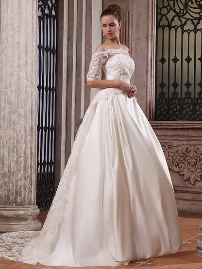 Close-up of the scalloped off-shoulder neckline and half sleeves of the wedding dress.