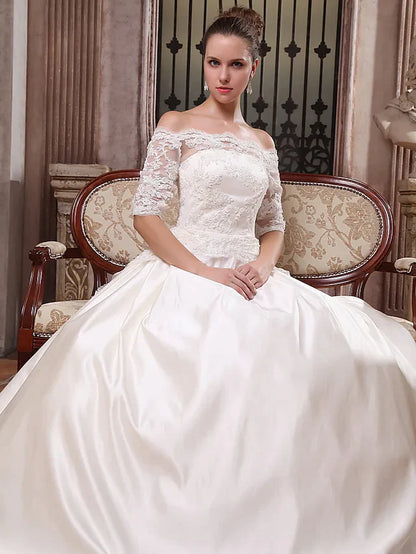 Full length view of the bride posing in the white off-shoulder wedding dress.