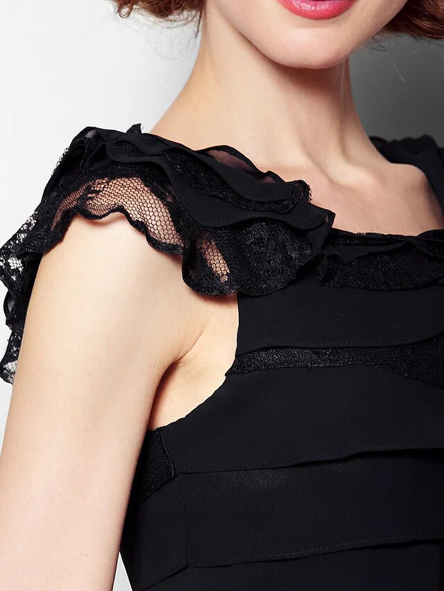 Woman in a black scoop neck dress, showcasing the lace and pleat details.
