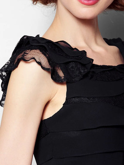 Woman in a black scoop neck dress, showcasing the lace and pleat details.