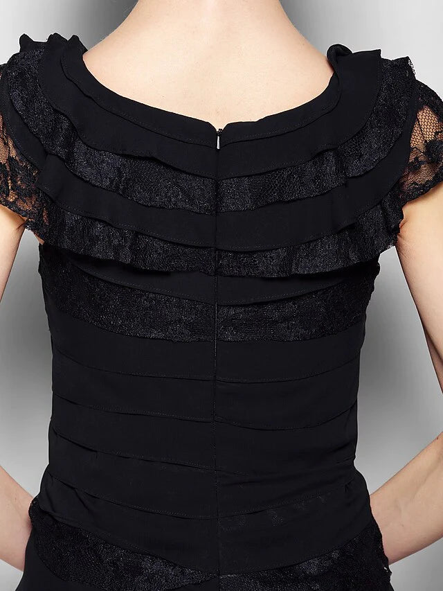 Woman in a black dress, highlighting the knee-length cut and elegant design.