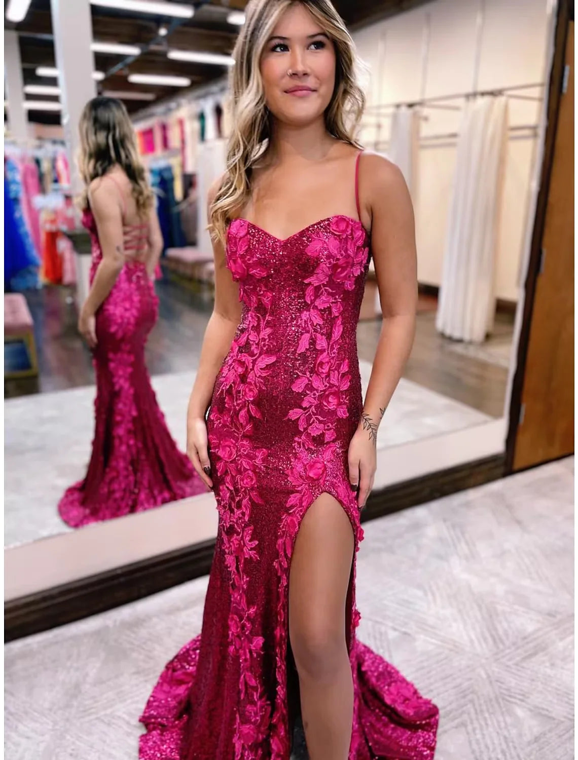 Woman wearing an elegant sequined mermaid evening gown with spaghetti straps and a sweep train.