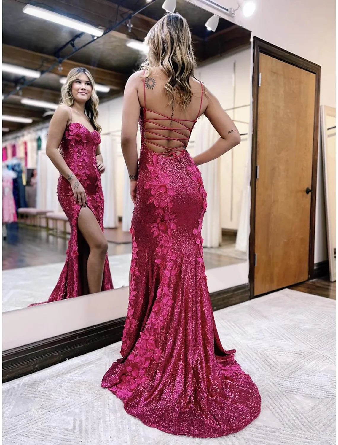 Side view of a woman in a sequined mermaid gown, highlighting the backless design and train.