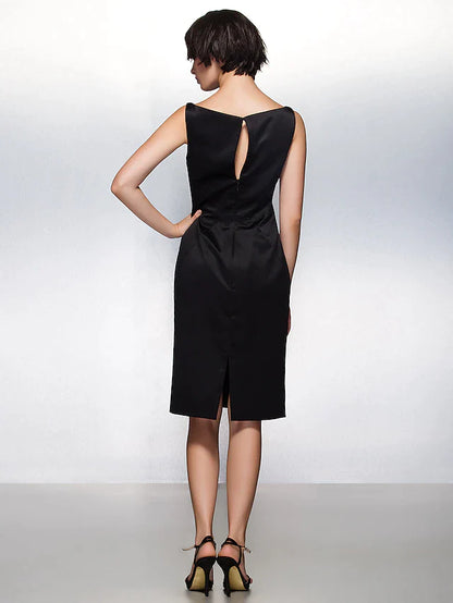 Side view of a woman in a dark blue satin sheath dress, highlighting pleats.