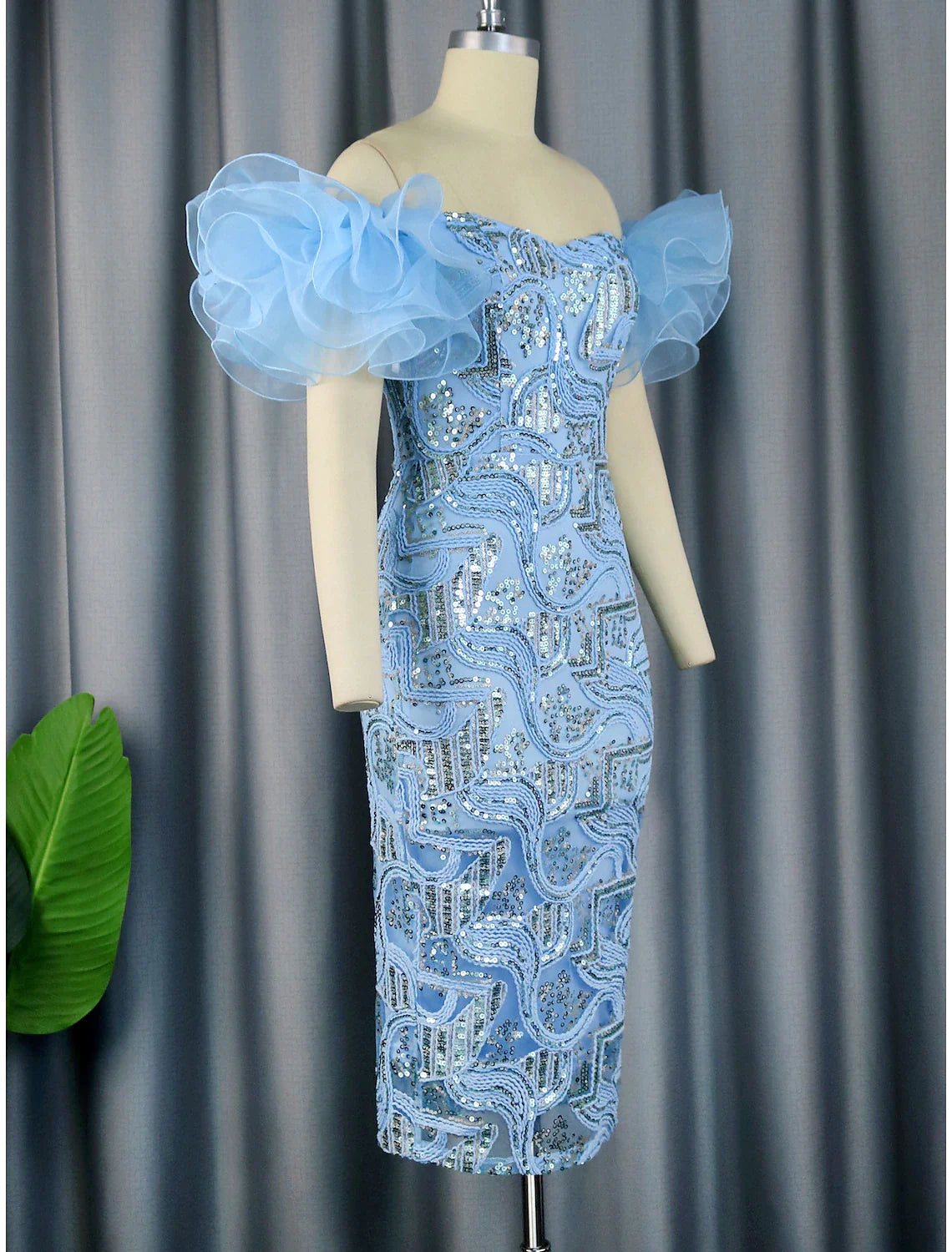 Side view of a model in a floral sequined off-shoulder party dress.