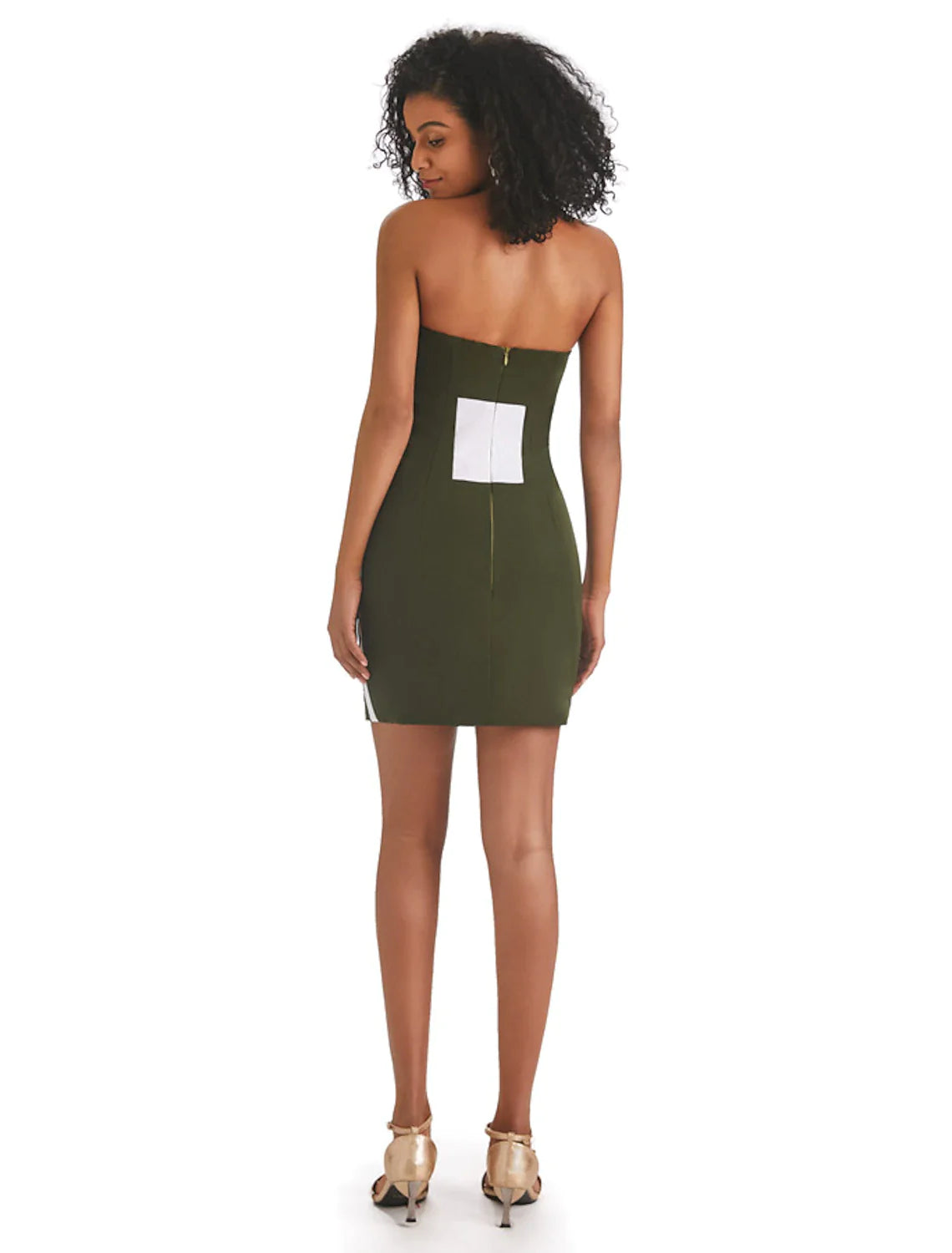 Side view of a woman in a strapless color block mini dress with fringe.
