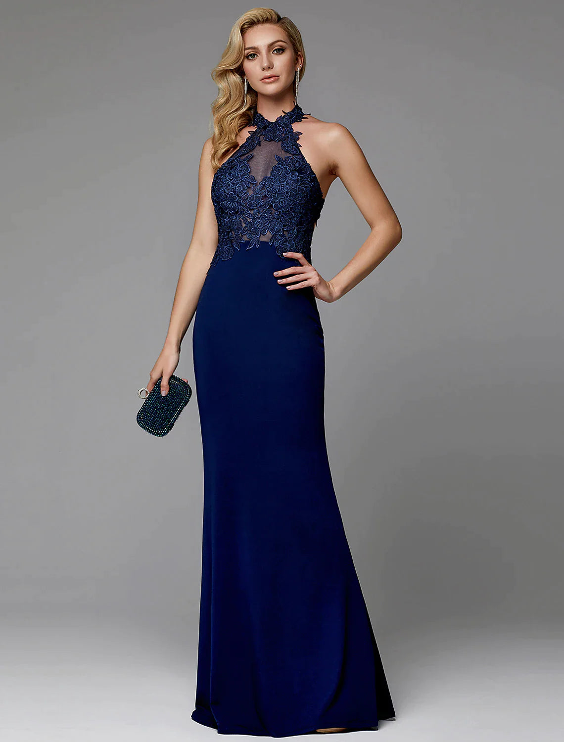 Model wearing a floor-length halter sheath evening gown with cut-outs and appliques.