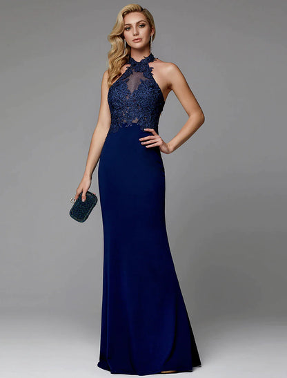 Model wearing a floor-length halter sheath evening gown with cut-outs and appliques.