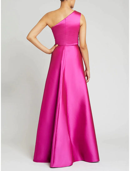 Model wearing a green one-shoulder satin sheath gown with an overskirt.