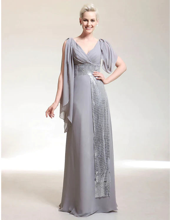 Elegant woman wearing a champagne sheath V-neck short sleeve chiffon evening dress with beading.