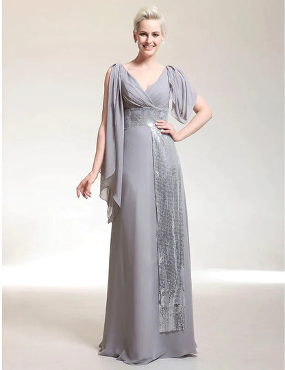 Elegant woman wearing a champagne sheath V-neck short sleeve chiffon evening dress with beading.
