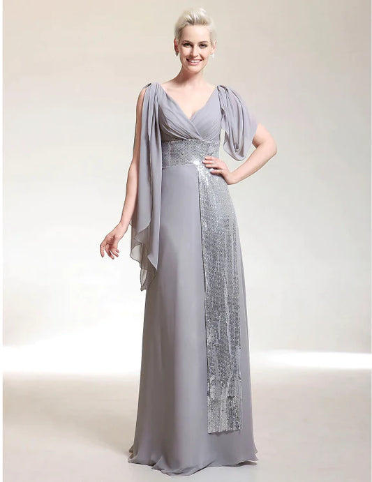 Elegant woman wearing a champagne sheath V-neck short sleeve chiffon evening dress with beading.