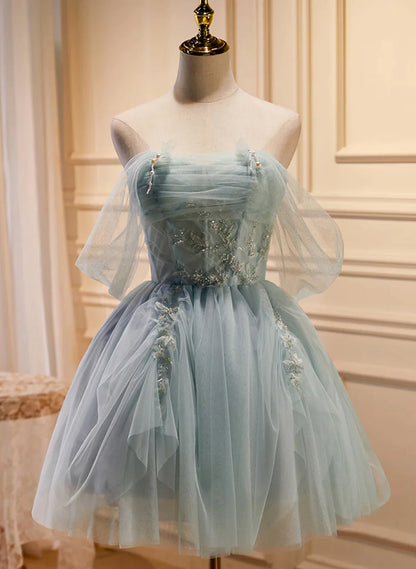 Model wearing a light green beaded tulle short prom dress with an A-line silhouette.