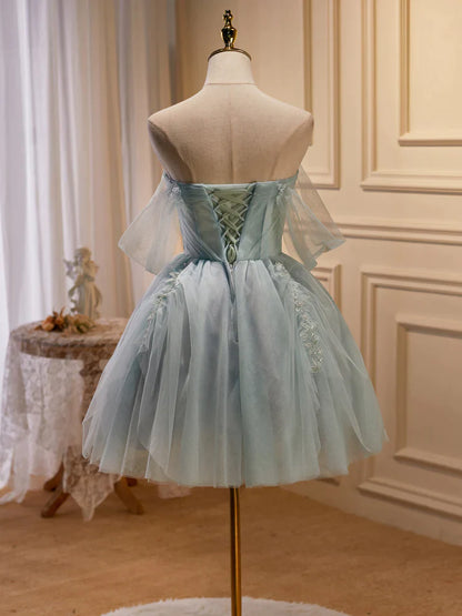 Close-up of the beaded bodice and delicate tulle fabric of the light green dress.