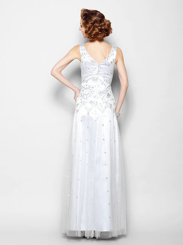 Side view of woman wearing a floor-length beaded Mother of the Bride dress.