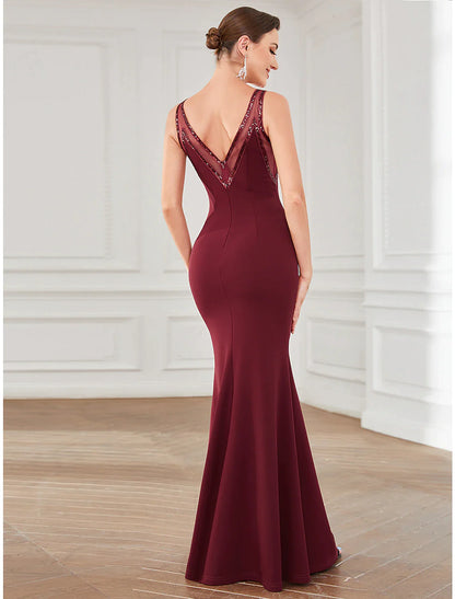 Back view of a woman in a sparkling floor-length evening gown.