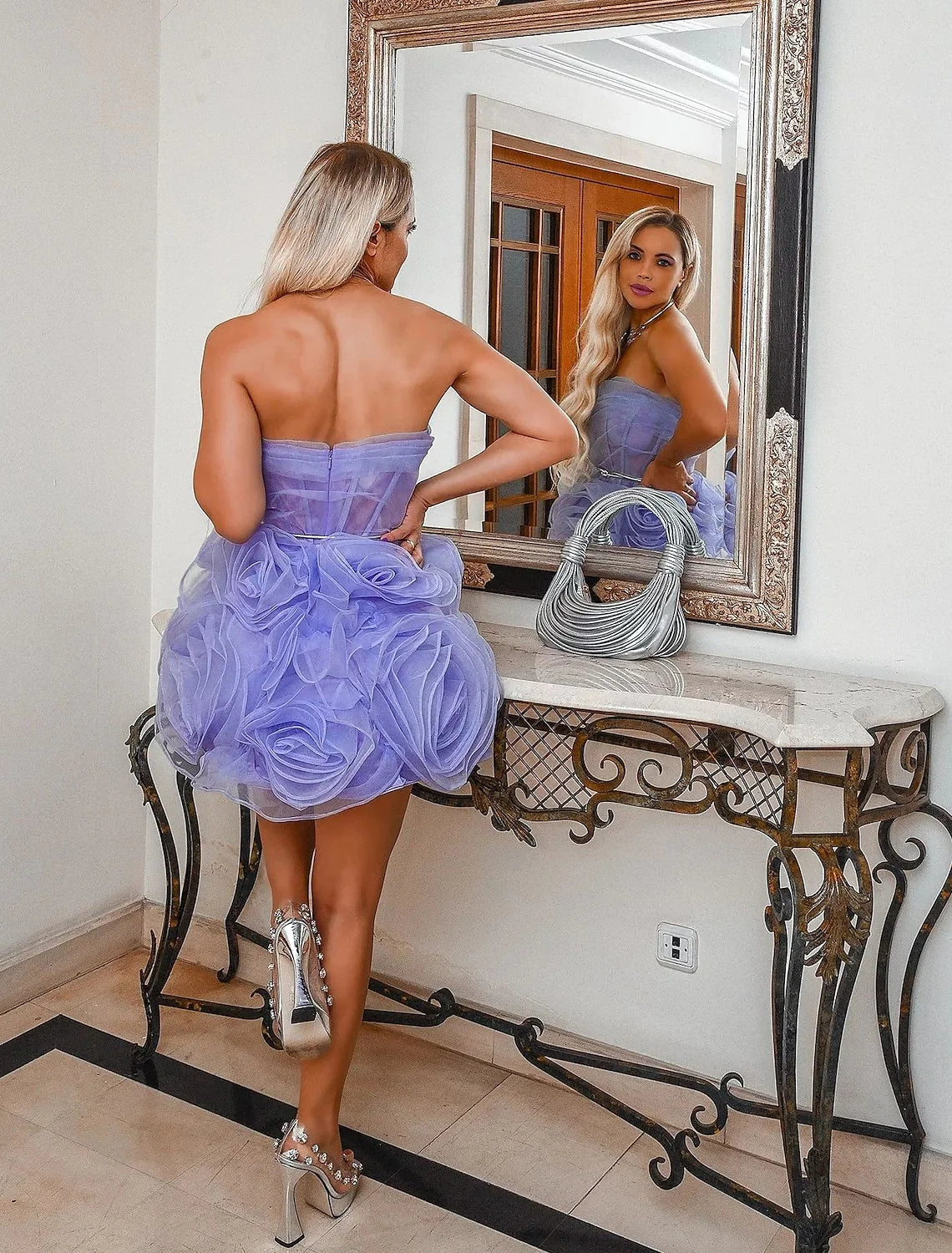 Side view of model in a strapless floral ruffled organza ball gown with a flowing court train.