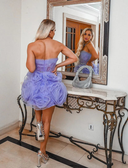 Side view of model in a strapless floral ruffled organza ball gown with a flowing court train.