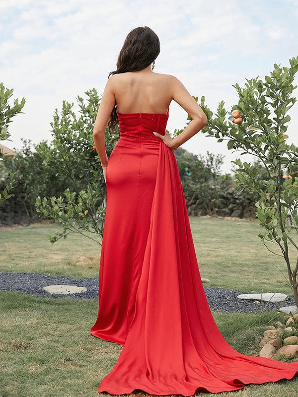 Side view of the red strapless ruched long prom dress, showing the flowing skirt.