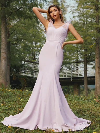 Woman wearing an elegant stretch crepe ruched V-neck sleeveless bridesmaid dress.