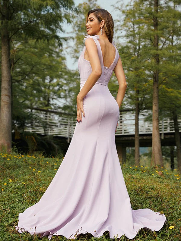 Side view of a woman in a stretch crepe ruched V-neck sleeveless bridesmaid dress.