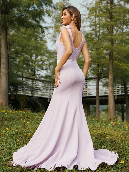Side view of a woman in a stretch crepe ruched V-neck sleeveless bridesmaid dress.