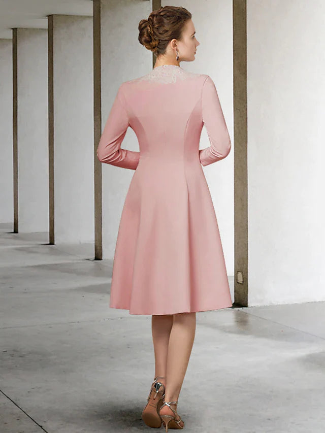 Woman posing in an elegant V-neck, half-sleeve, knee-length Mother of the Bride dress with appliques.