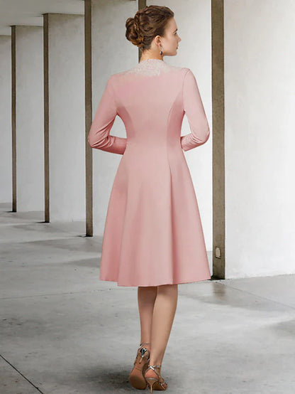 Woman posing in an elegant V-neck, half-sleeve, knee-length Mother of the Bride dress with appliques.