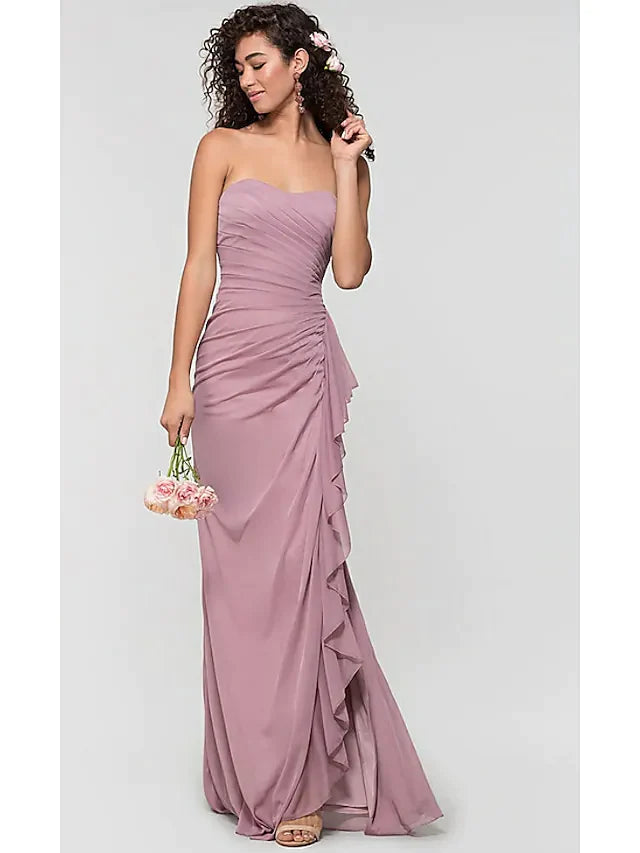 Woman wearing an elegant light blue sweetheart chiffon bridesmaid dress with ruffles, a split front, and an open back.