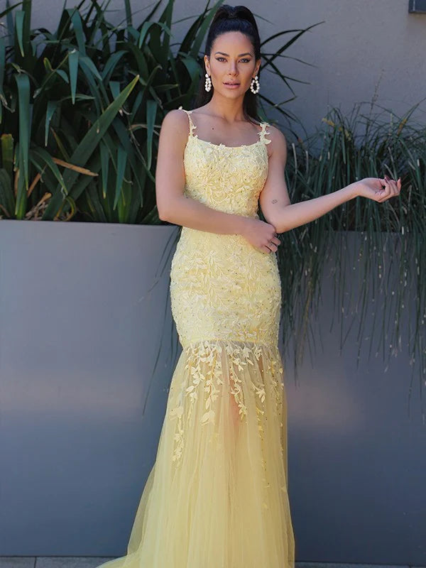 Elegant yellow tulle prom dress with spaghetti straps and applique detailing.